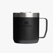 Matte black Stanley insulated mug with stainless steel rim and handle on a white background.