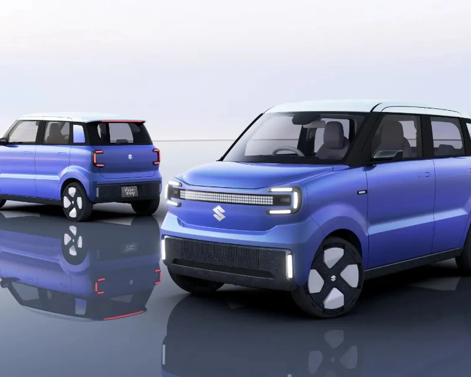 Two blue Suzuki compact electric cars with white roofs and modern LED lights on a reflective surface.