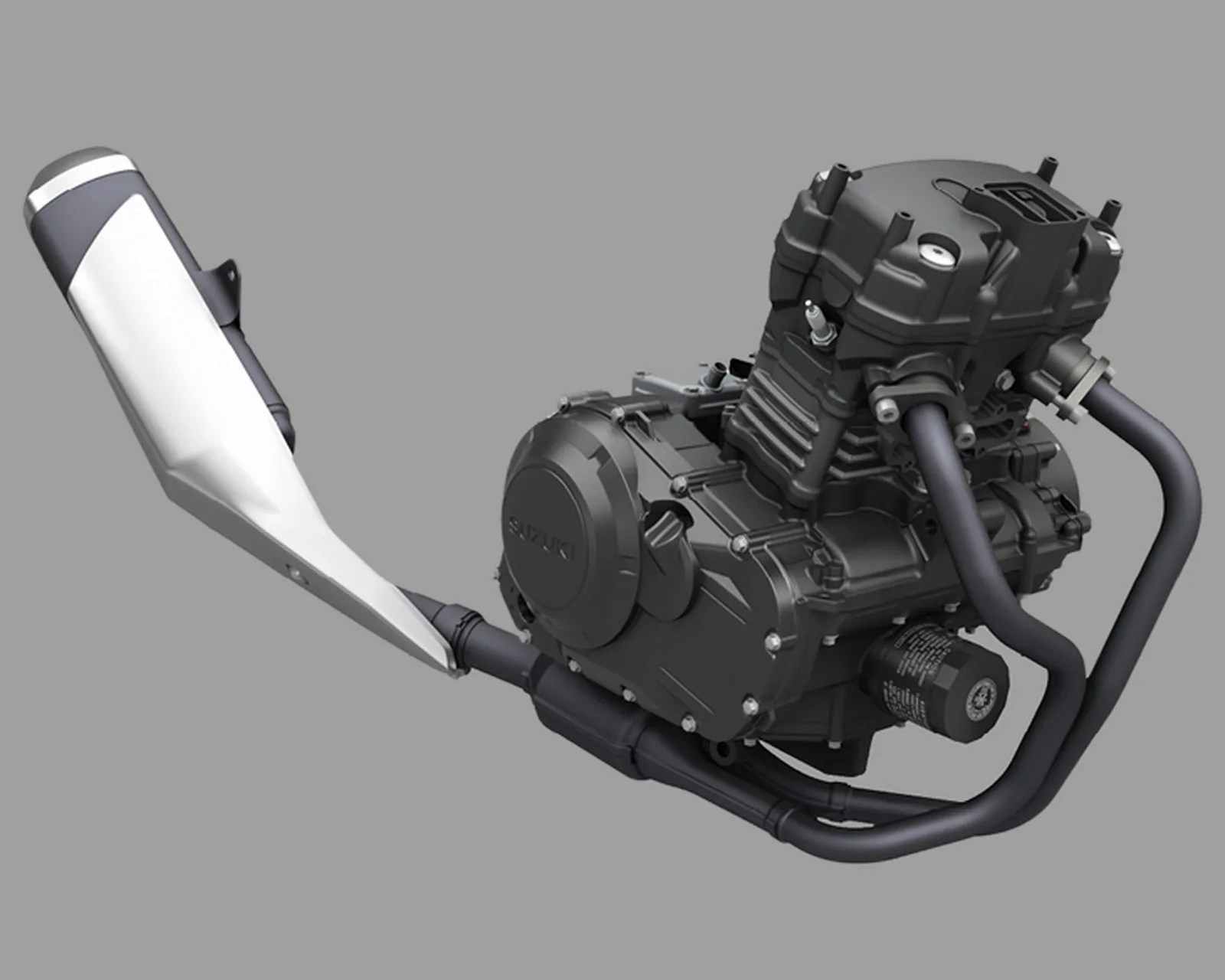 Black Suzuki motorcycle engine with attached black exhaust pipes and silver muffler on gray background.