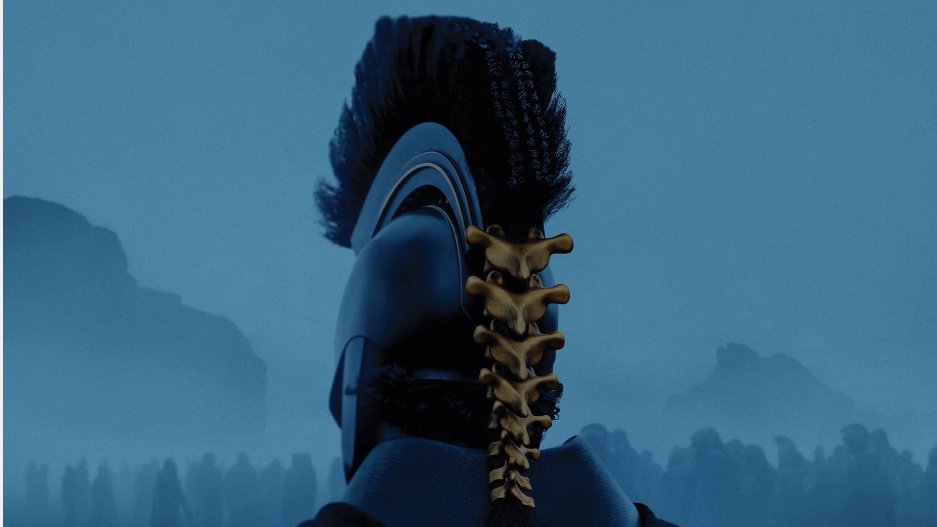 Back view of a blue helmet with a black mohawk and a spine-like golden ornament attached to the back, set against a misty blue mountainous background.