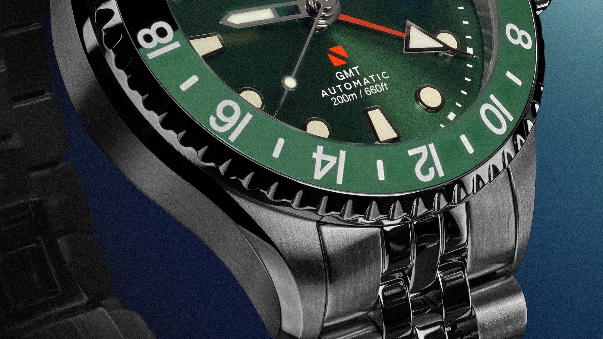 Close-up of a stainless steel watch with a green bezel, green dial, luminous markers, and a metal bracelet.