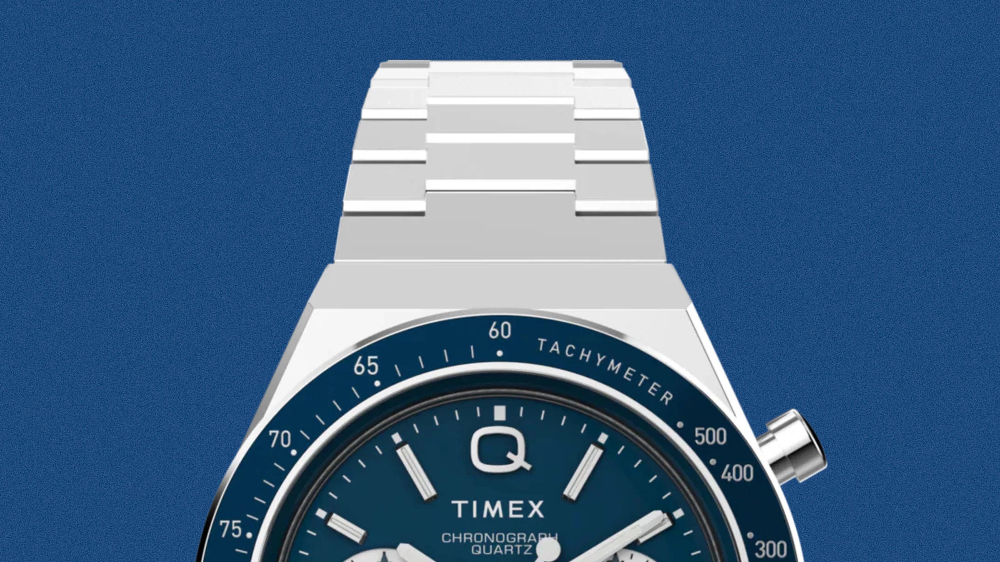 Silver metal watch band attached to a blue Timex chronograph watch face with tachymeter markings.