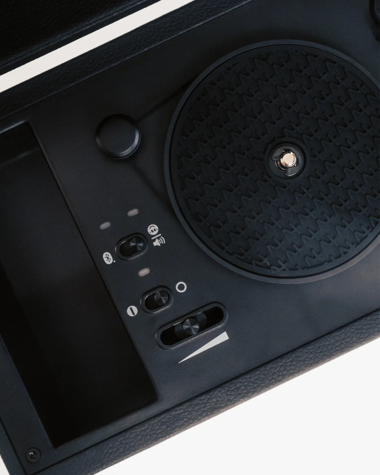 Close-up of a black car wireless charging pad with Bluetooth and speaker control switches.