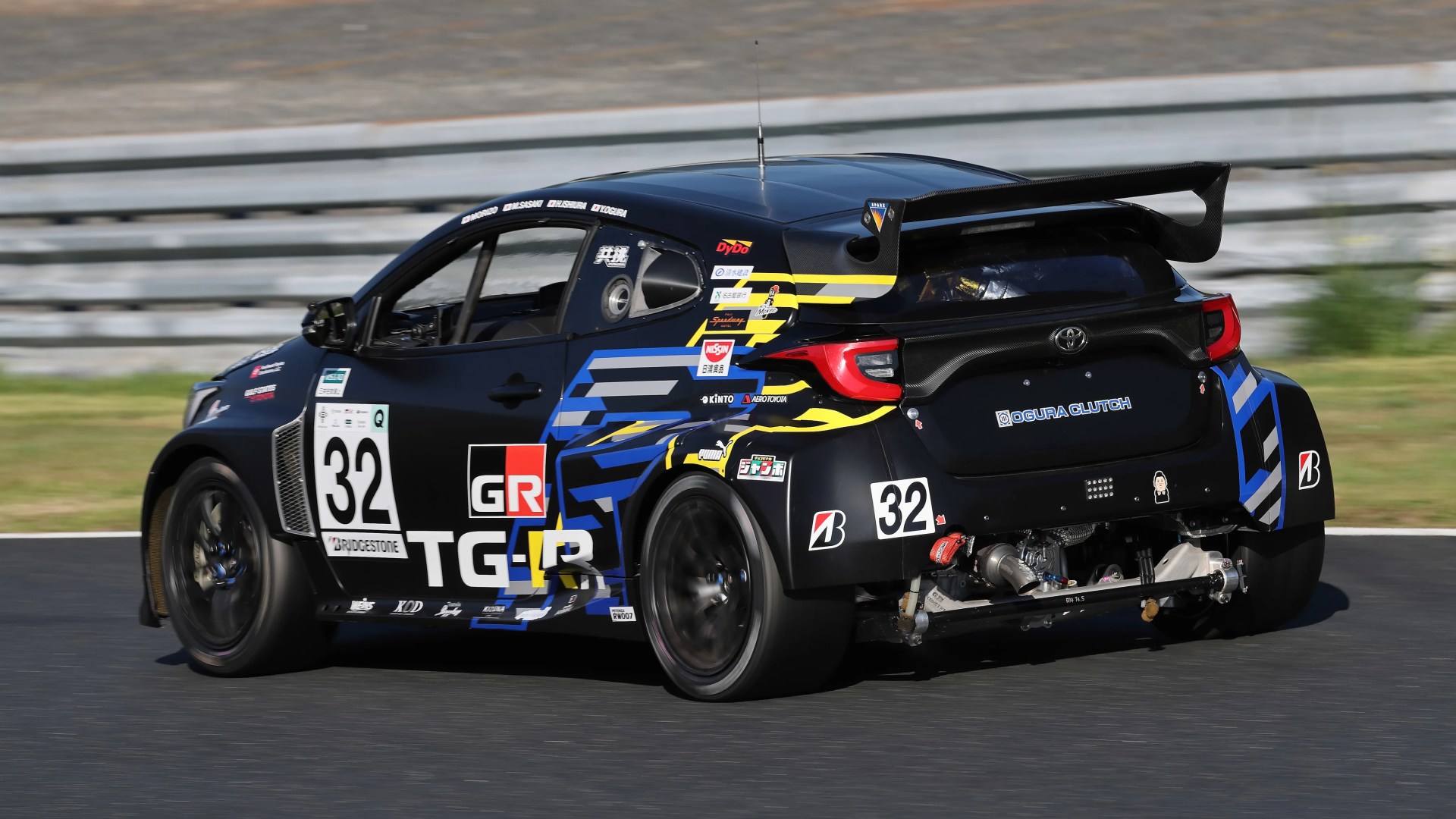 Black and blue Toyota race car number 32 with large rear wing on a racetrack.