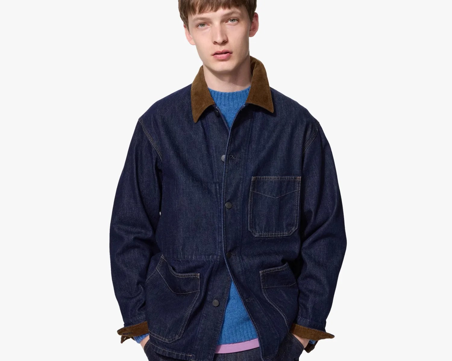 Dark blue denim jacket with brown corduroy collar and cuffs worn over a blue sweater.