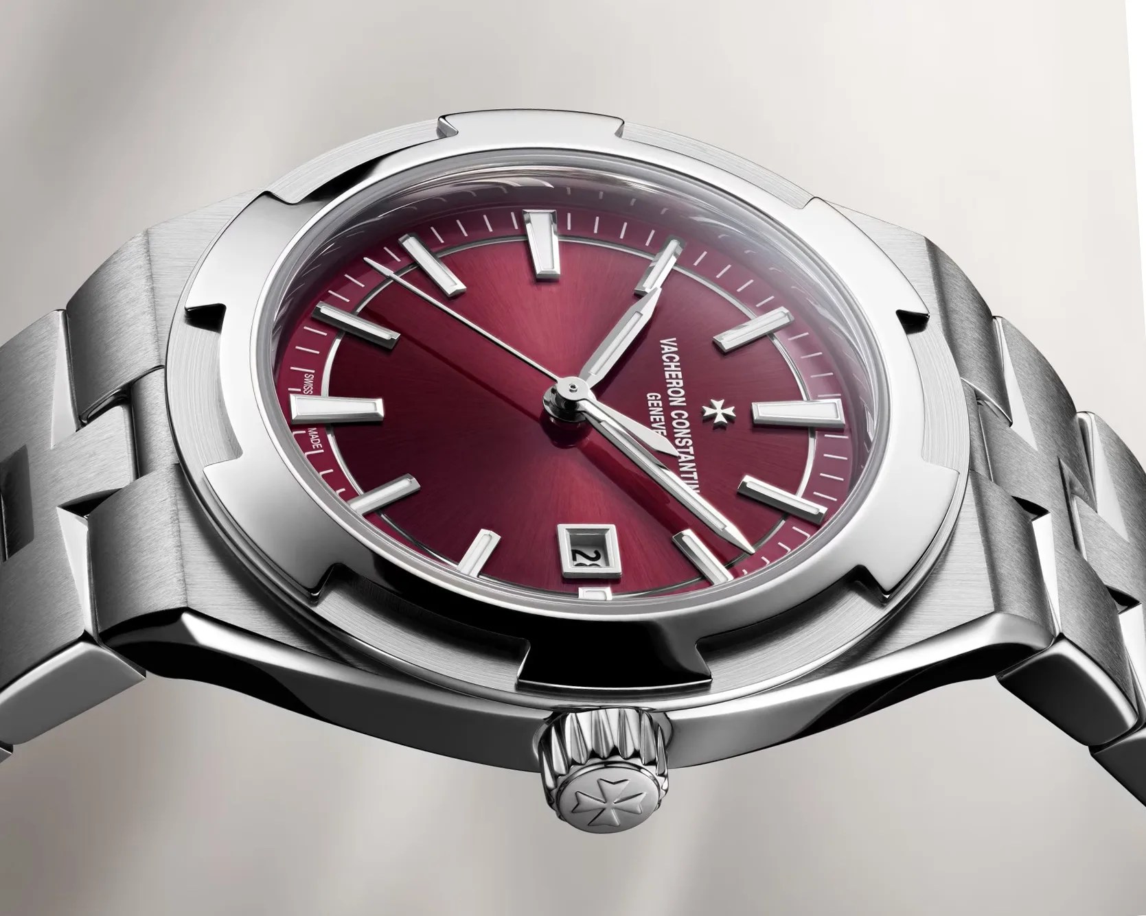 Stainless steel wristwatch with a deep red dial, silver hour markers, date window, and a linked bracelet.