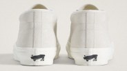 Pair of off-white suede sneakers shown from the back with black skateboard logo on the white rubber sole.