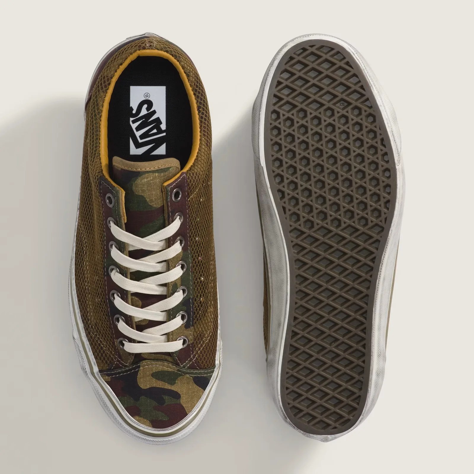 Pair of brown and camouflage Vans sneakers, one showing top with white laces, the other showing waffle-pattern sole.
