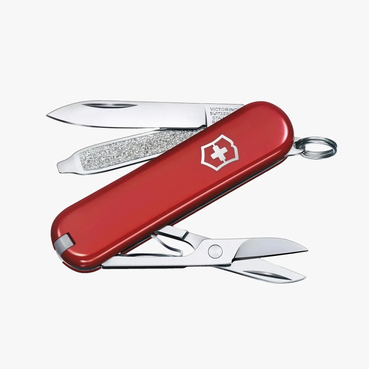 Red Swiss Army knife with a small blade, nail file, and scissors partially extended.