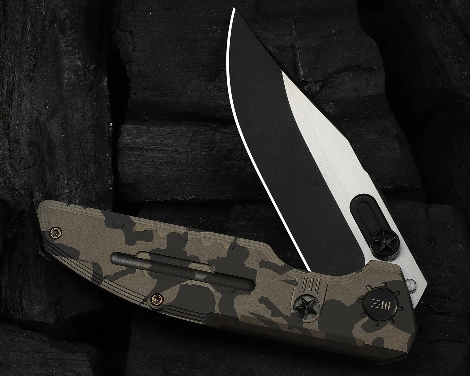 Folding knife with a black and silver blade and a camo-patterned handle on a dark textured surface.