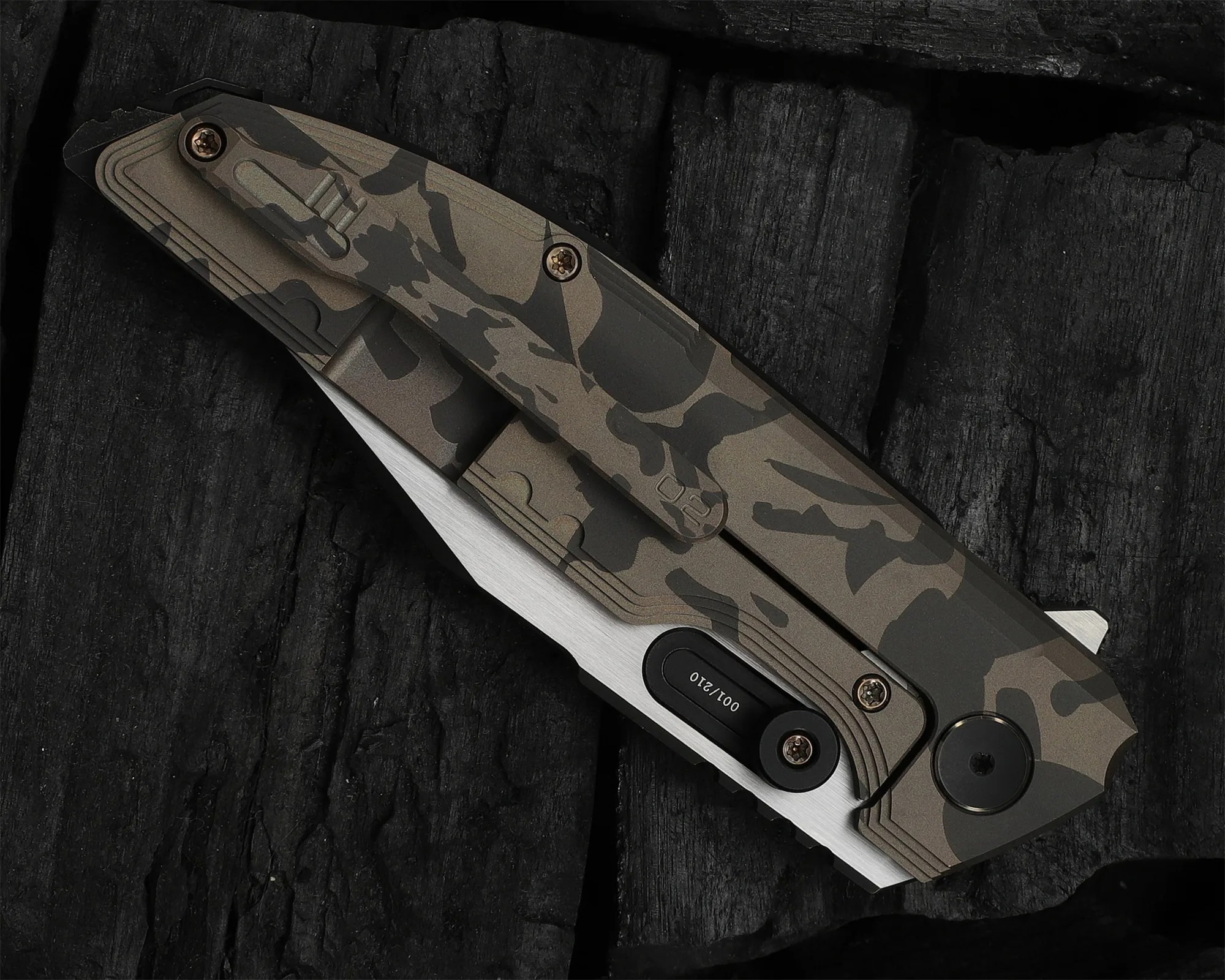 Folding knife with a camo-patterned handle and partially visible silver blade on a black textured surface.