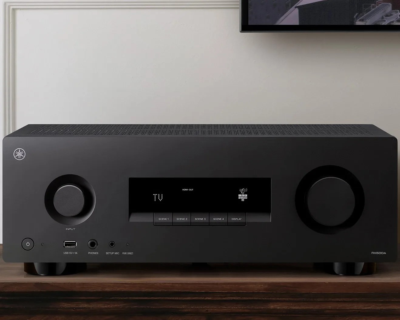 Black Yamaha RX500A AV receiver with digital display and control knobs on a wooden surface.