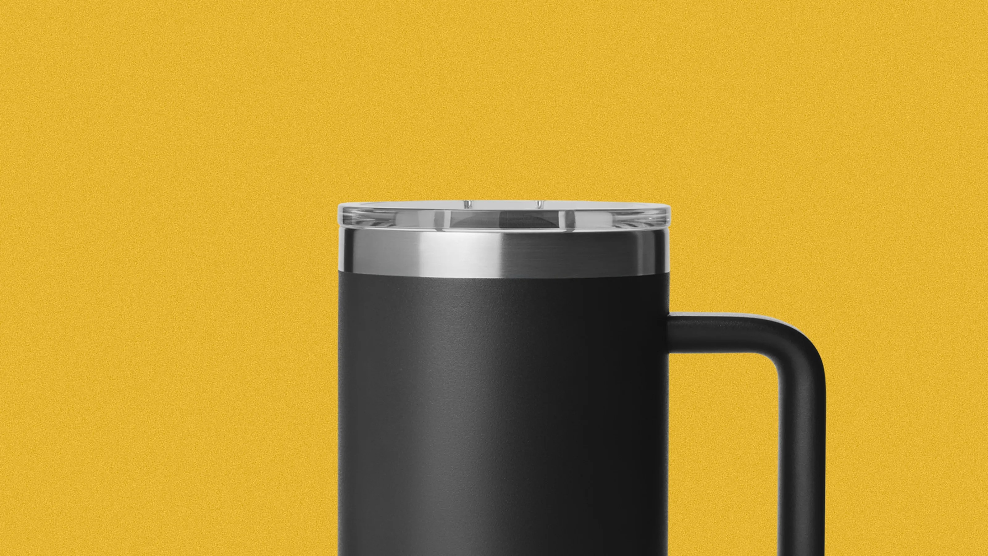 Black insulated travel mug with clear lid and stainless steel rim against a yellow background.