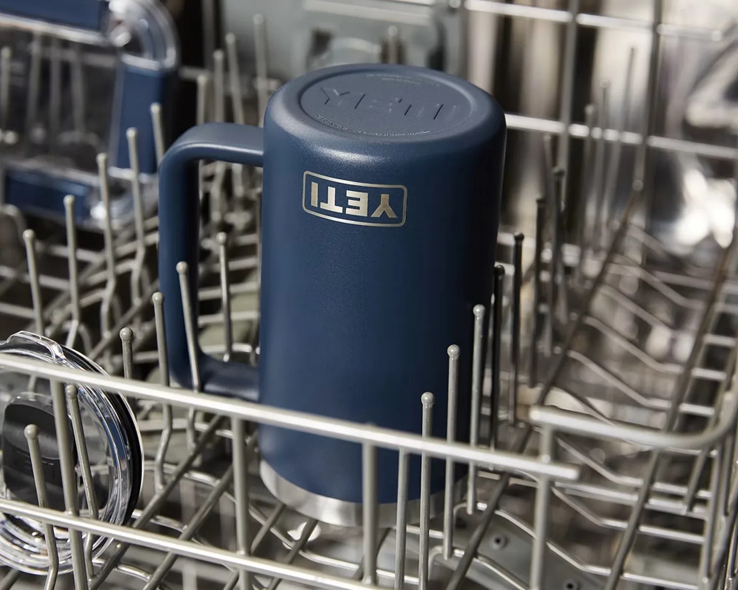 Blue YETI insulated mug upside down inside a dishwasher rack.