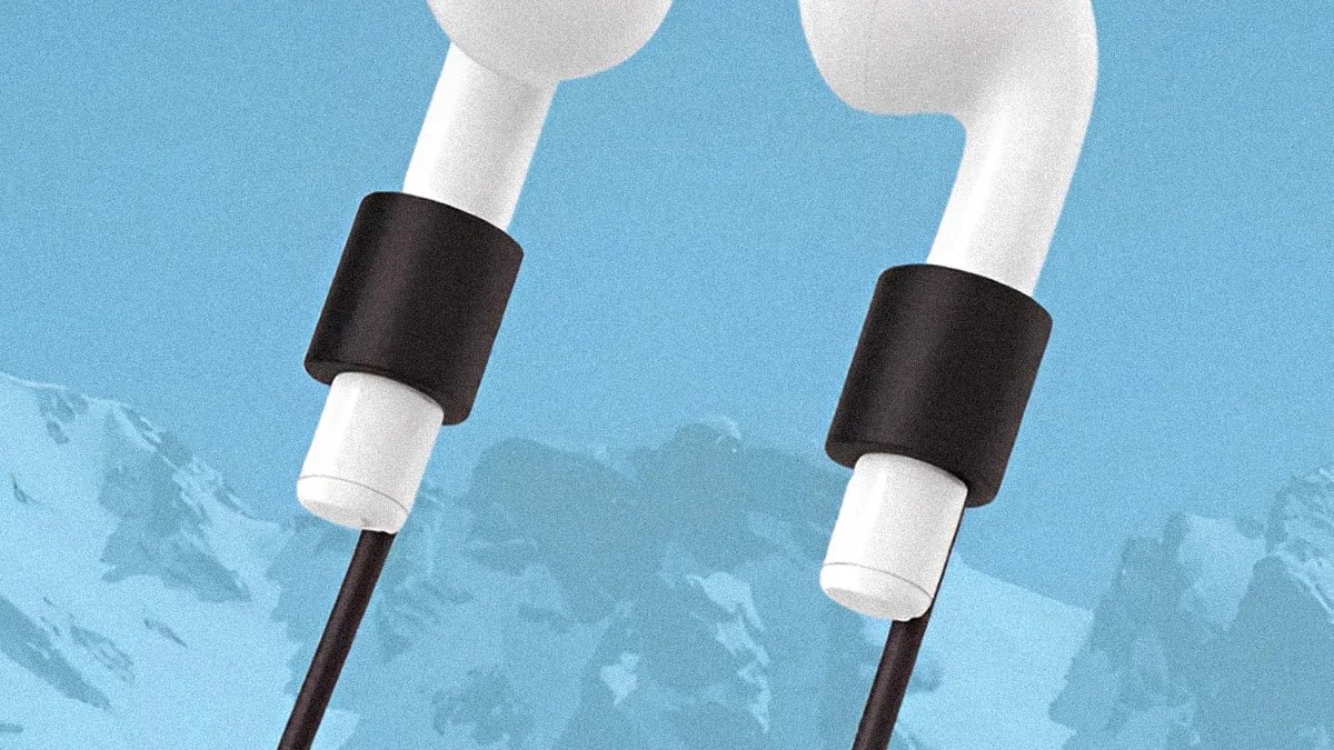 White wireless earbuds with black silicone cable organizers against a blue background with mountain silhouettes.