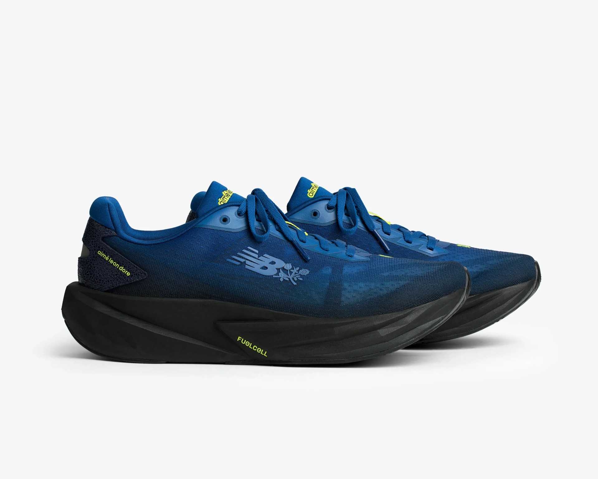 Pair of blue New Balance running shoes with black thick soles and yellow "FuelCell" and "aimé leon dore" text accents.