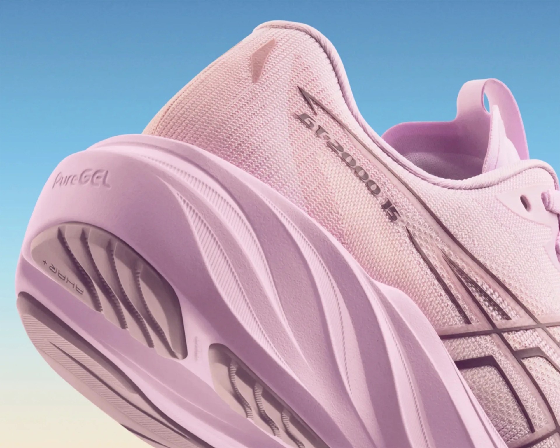 Close-up of a pink ASICS running shoe with PureGEL cushioning and FlyteFoam midsole against a blue sky.