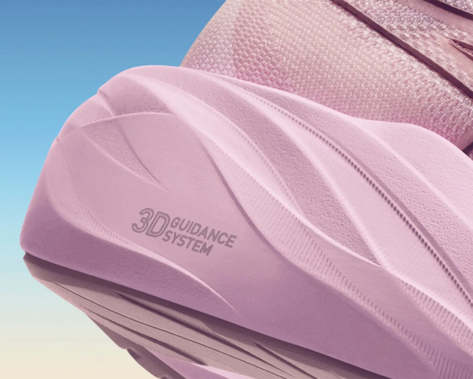 Pink shoe sole with textured grooves and "3D Guidance System" text on a blue sky background.