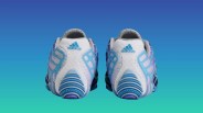 Pair of white and blue Adidas running shoes viewed from the back against a blue gradient background.