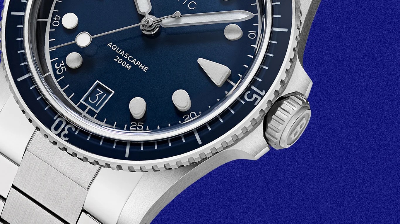 Close-up of a silver stainless steel wristwatch with a blue dial, rotating bezel, and date window showing "31".