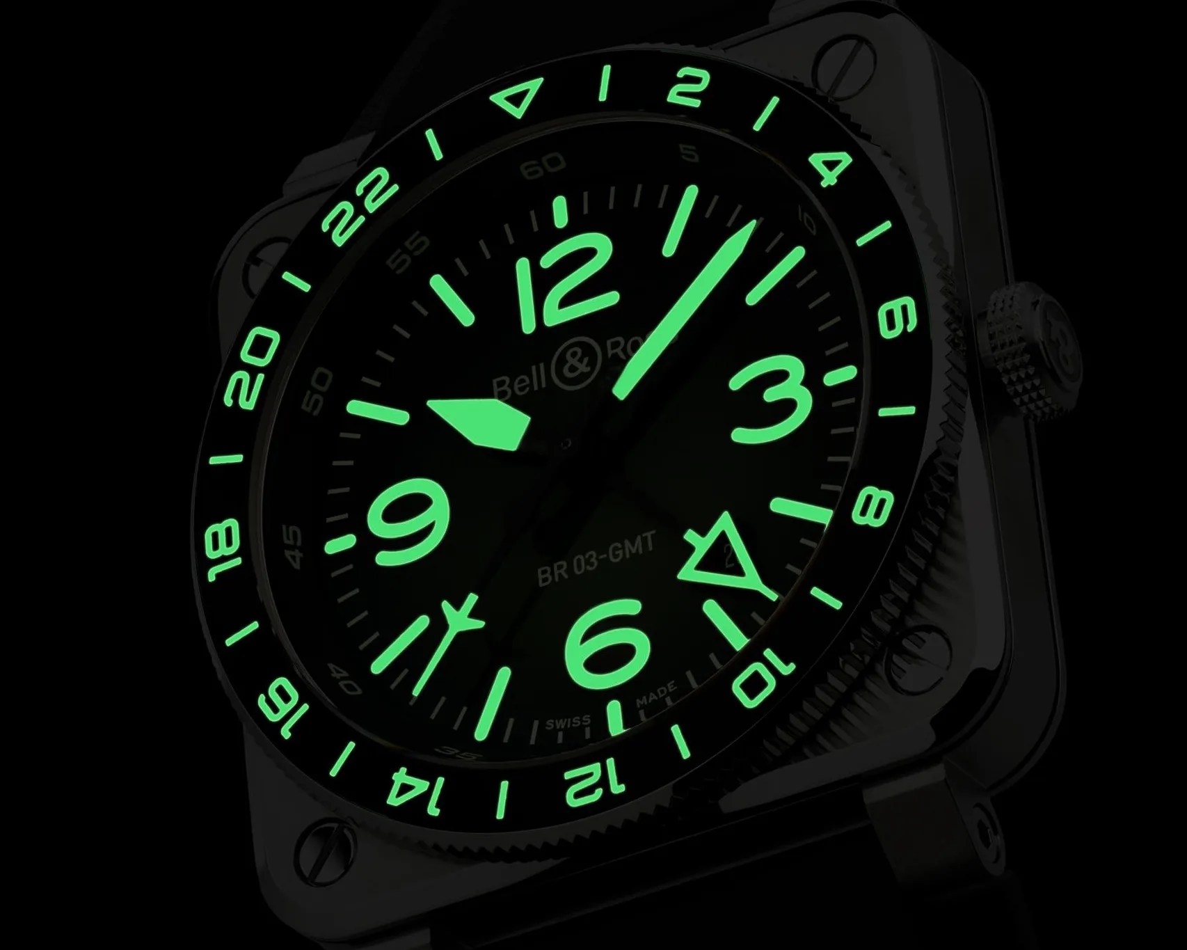 Close-up of a Bell & Ross BR 03-GMT watch face with glowing green numerals and hands in the dark.
