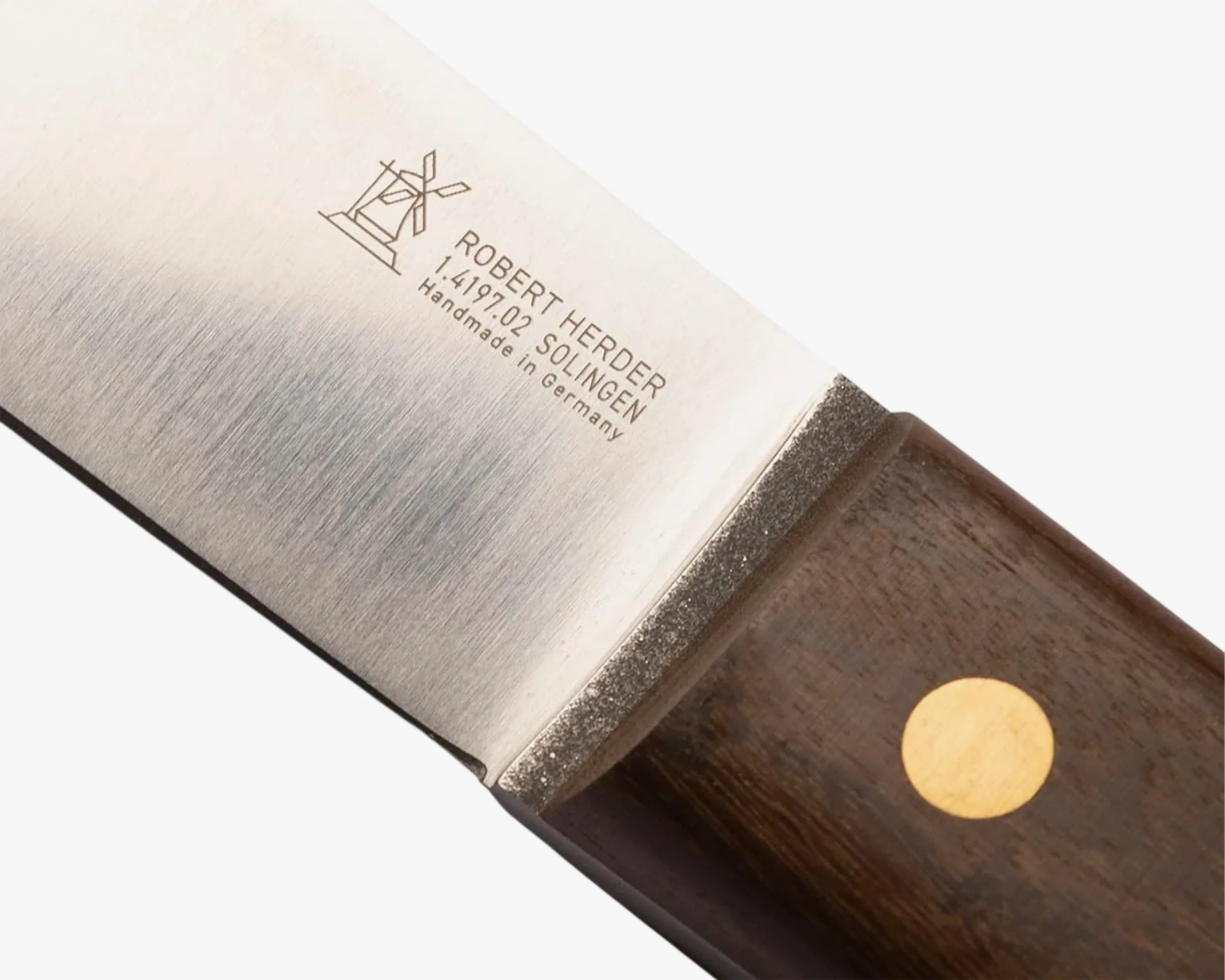 Close-up of a Robert Herder Solingen knife blade with wooden handle and brass rivet.