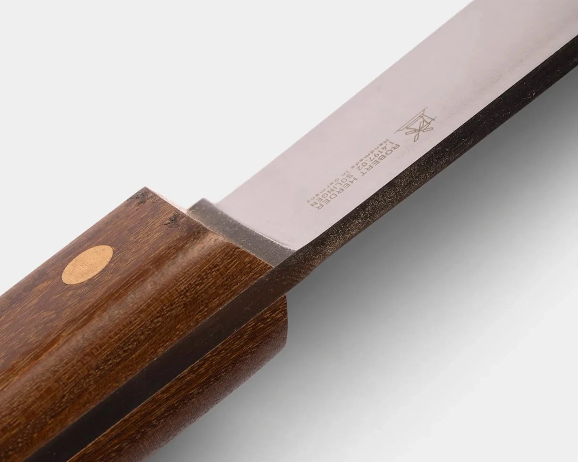 Close-up of a knife blade with "Robert Herder Solingen Germany" engraving and a wooden handle with a light oval inlay.