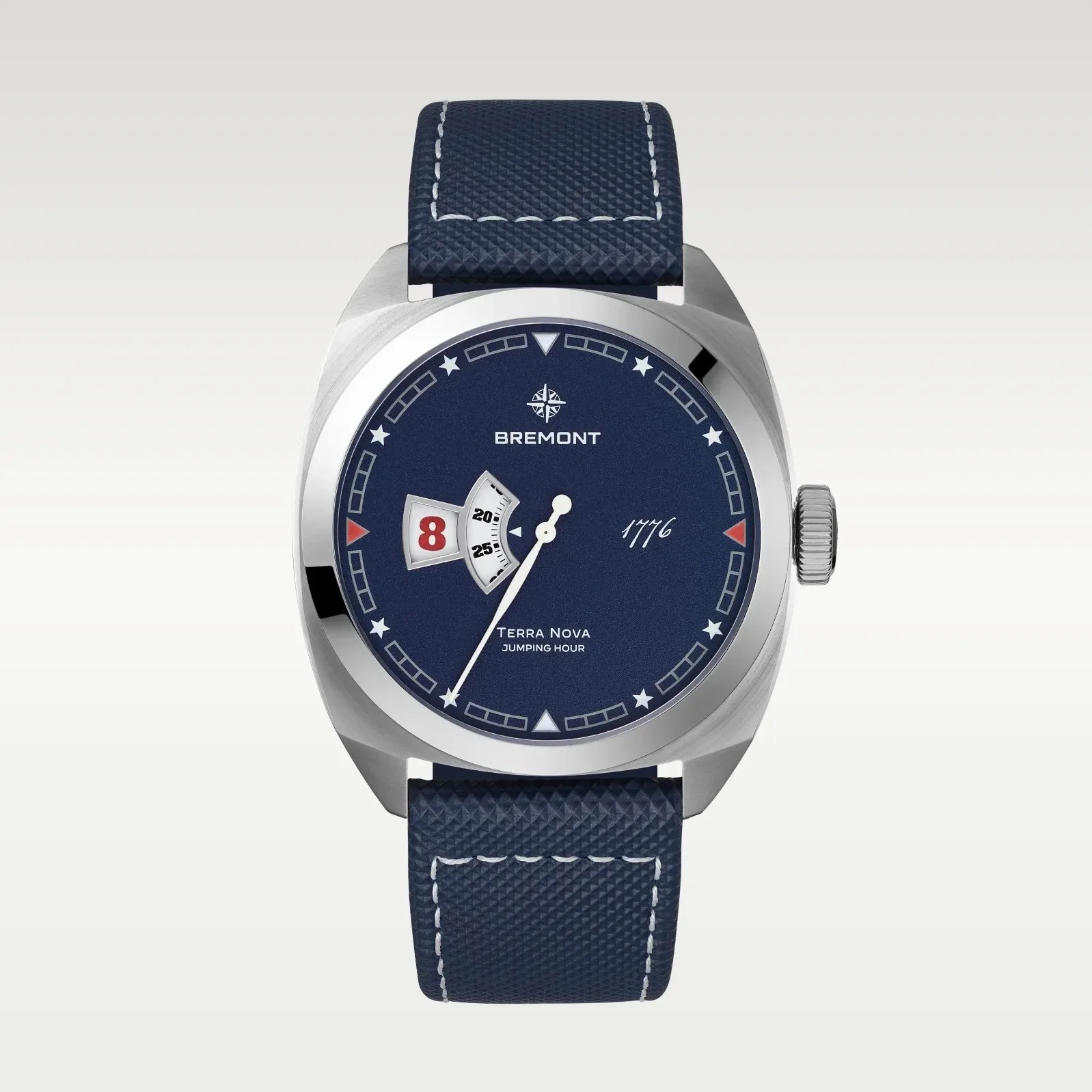 Blue Bremont Terra Nova watch with white star hour markers, red date window, and textured blue strap.