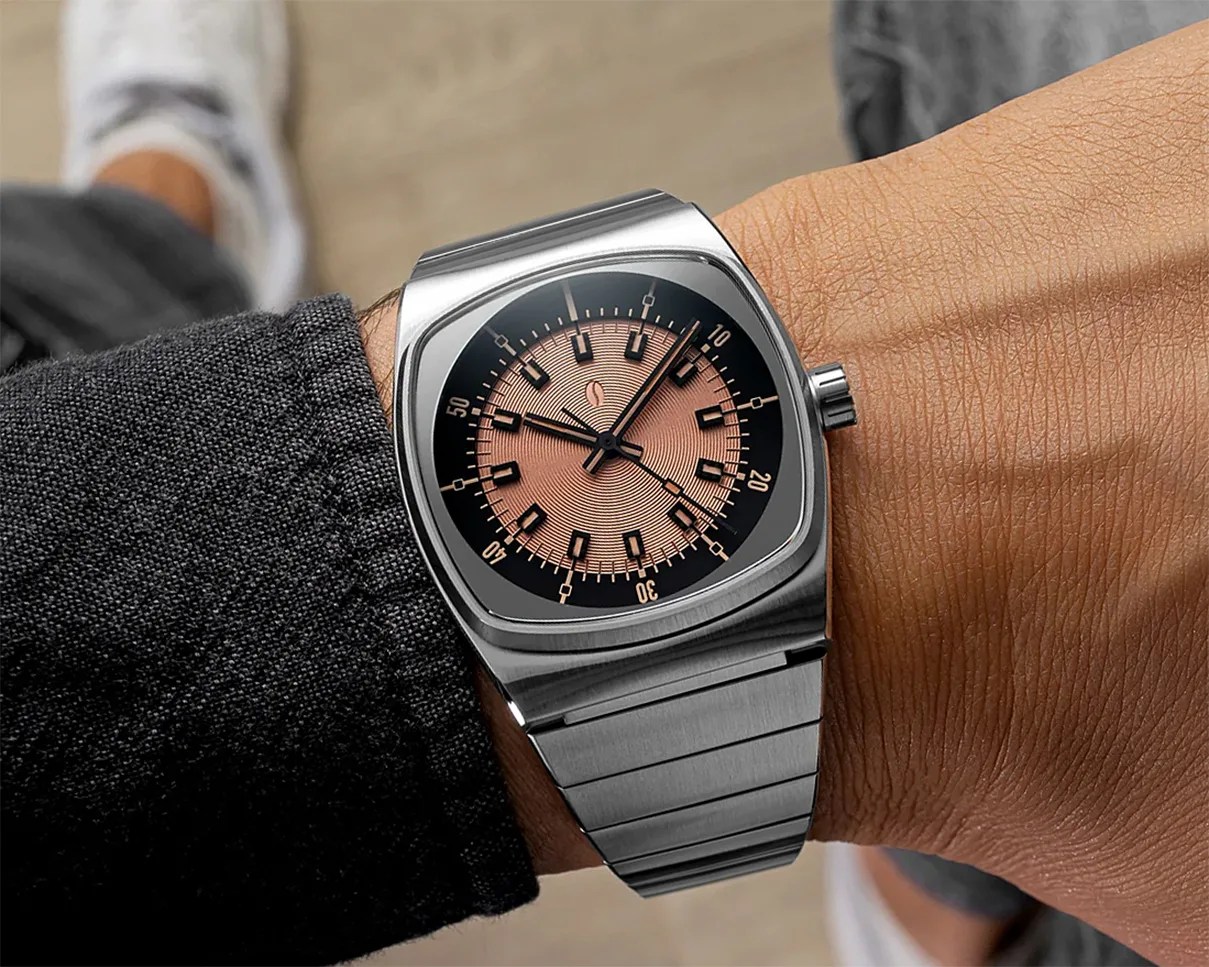 Stainless steel wristwatch with a square case and a copper-toned dial featuring black hour markers and a matching metal bracelet.