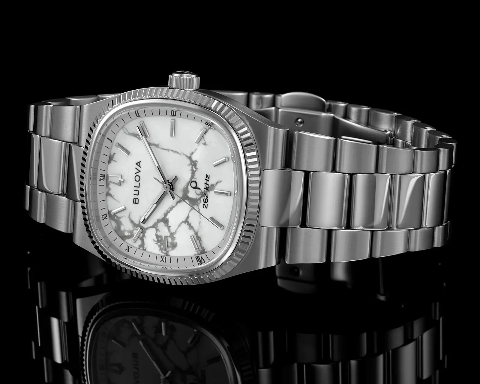 Stainless steel Bulova wristwatch with a white marble-patterned dial and silver hour markers on a black reflective surface.