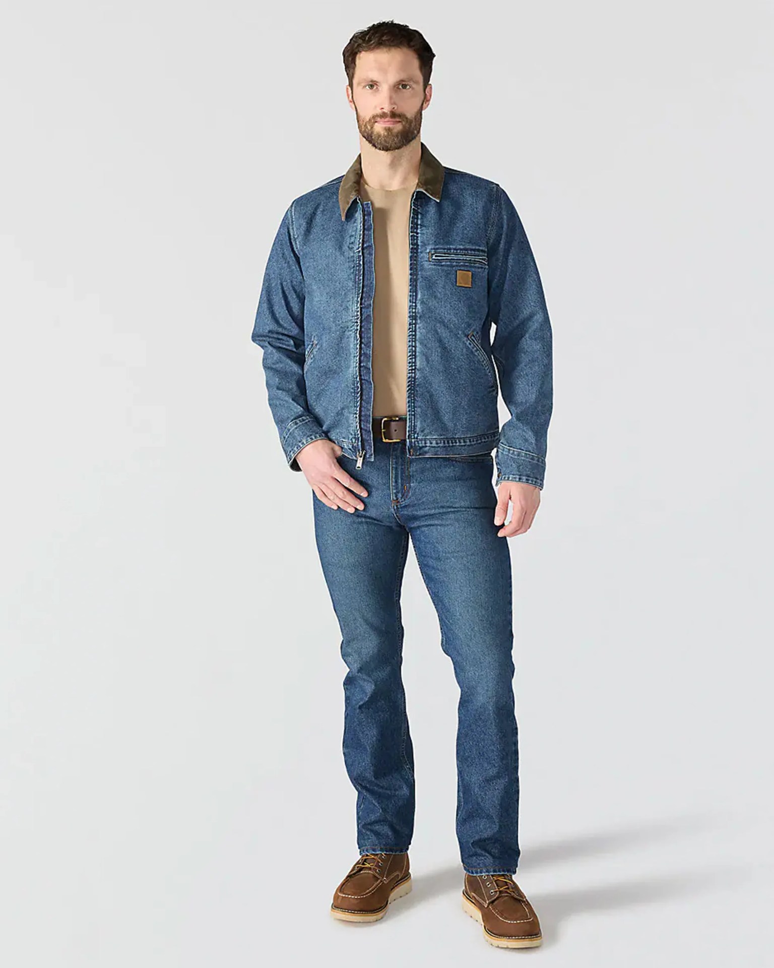 Man wearing blue denim jacket with brown collar, blue jeans, tan shirt, and brown leather boots.