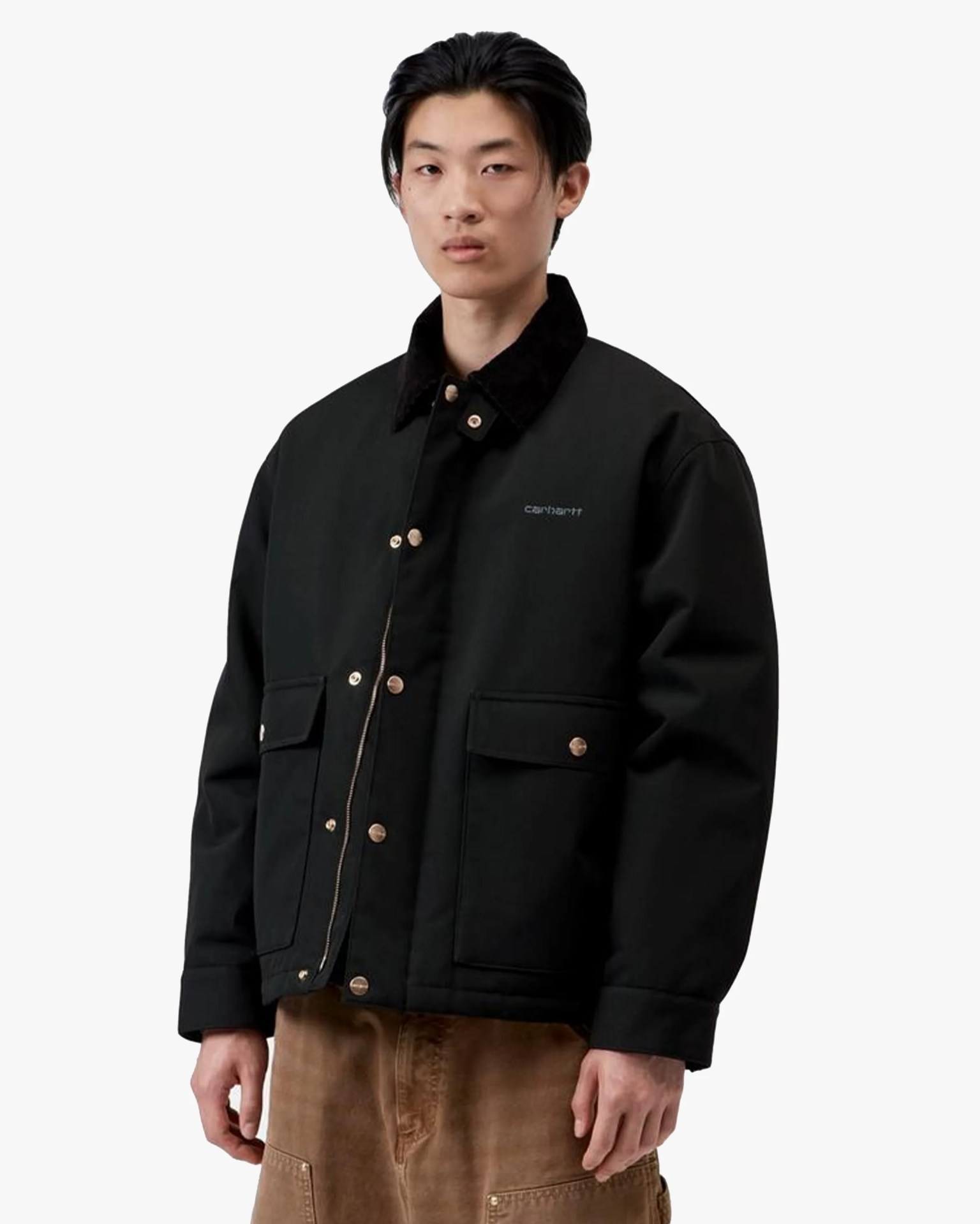 Black Carhartt jacket with snap buttons and flap pockets worn by a person.
