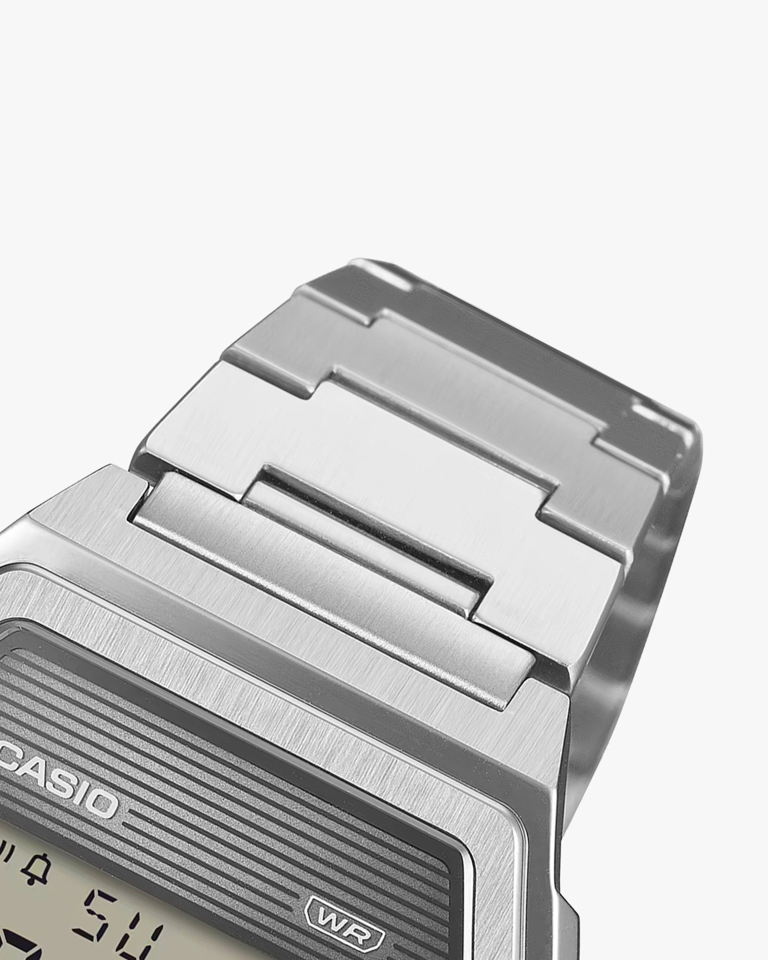 Close-up of a silver metal watch band and part of a Casio digital watch face.