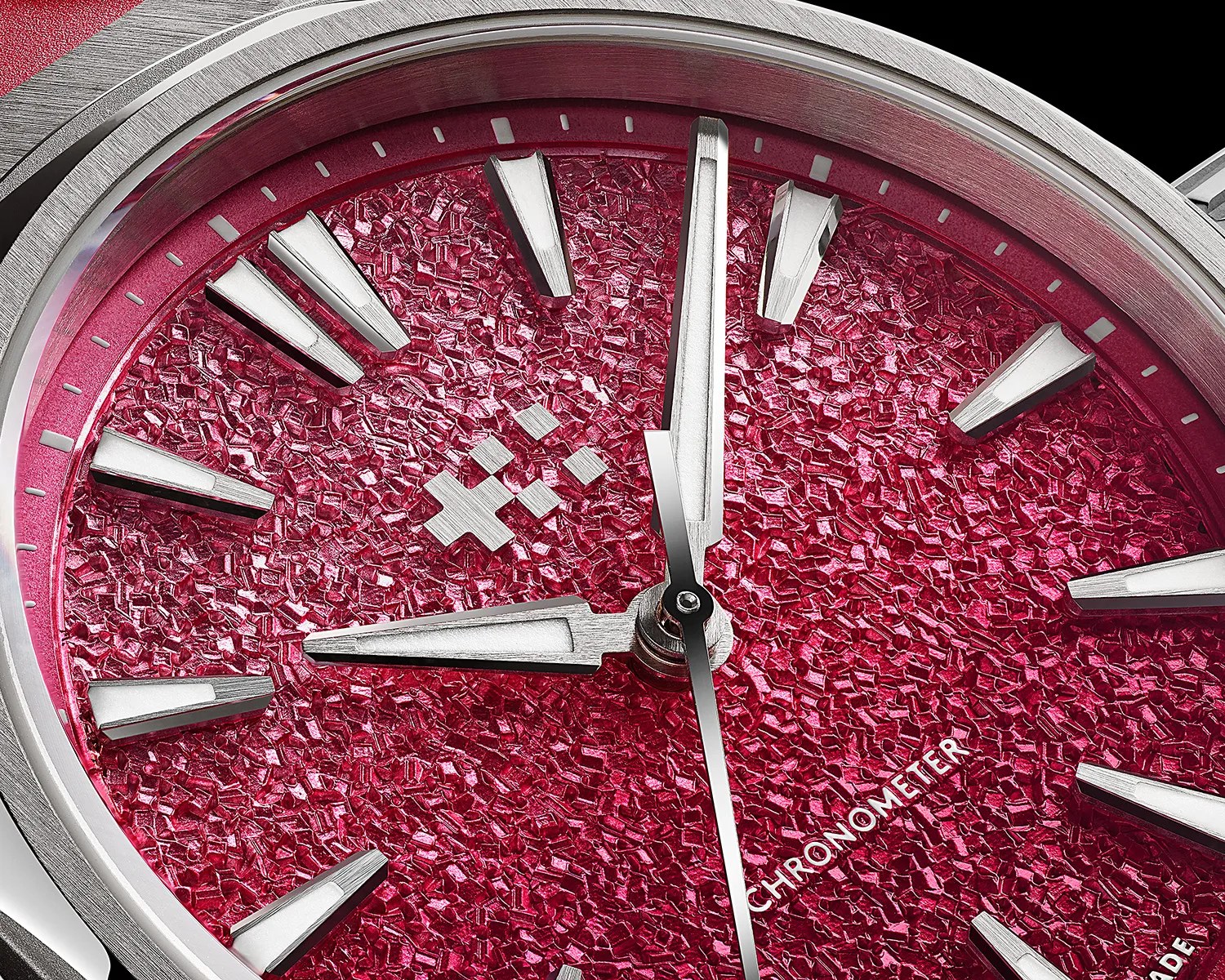 Close-up of a silver watch with a textured red dial and silver hour markers and hands.