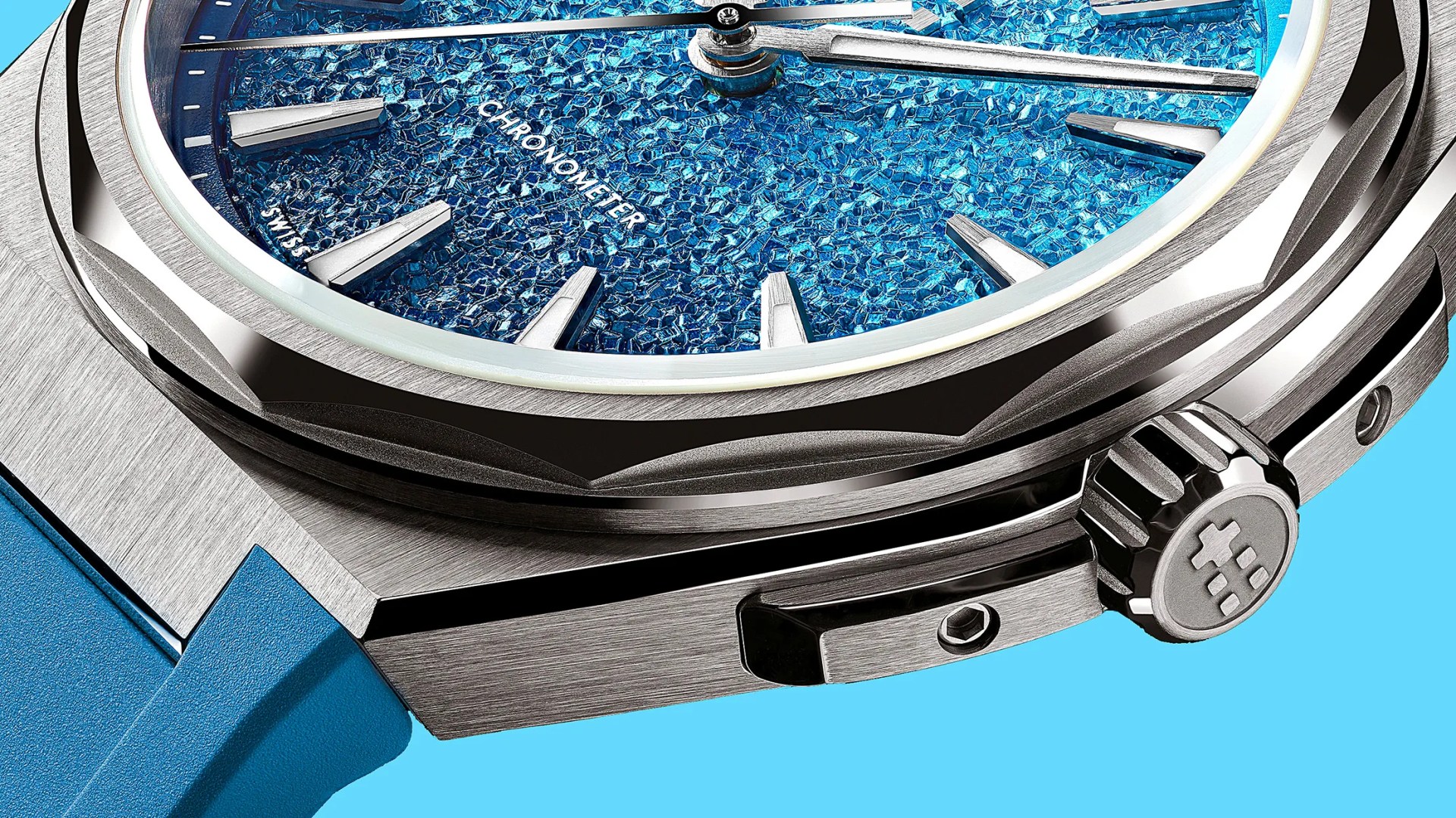 Close-up of a luxury watch with a textured blue dial, silver hour markers, brushed metal case, and blue strap.