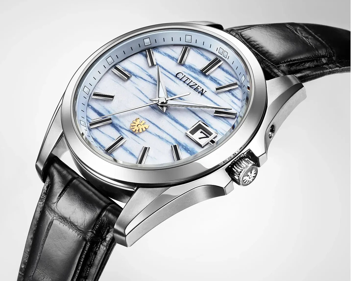 Citizen wristwatch with a silver case, blue and white striped dial, black leather strap, and date display at 3 o'clock.