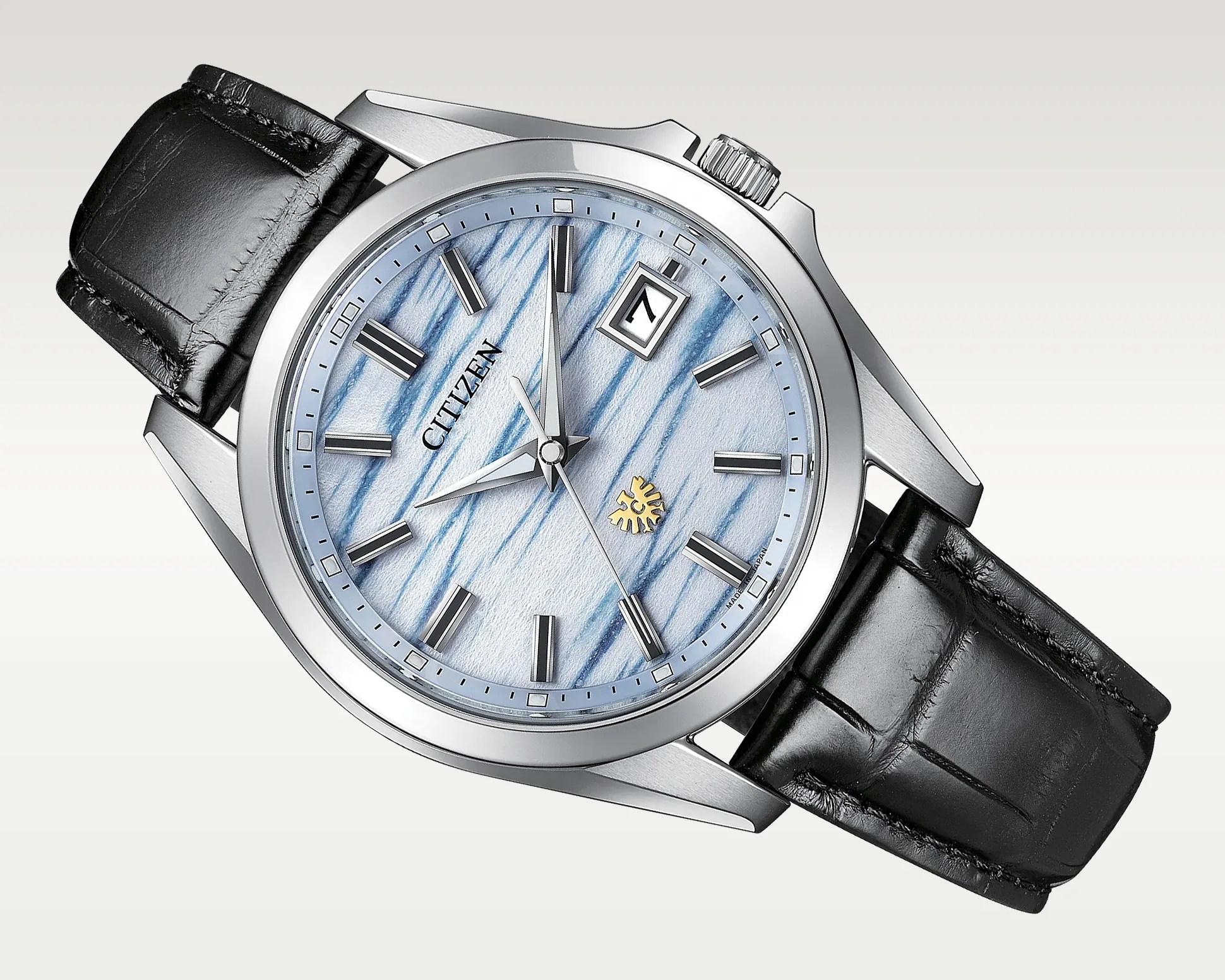 Citizen wristwatch with a silver case, blue and white textured dial, black leather strap, and date window at 3 o'clock.