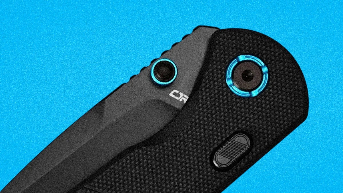 Black folding knife with textured handle and blue accents on pivot and button against a blue background.