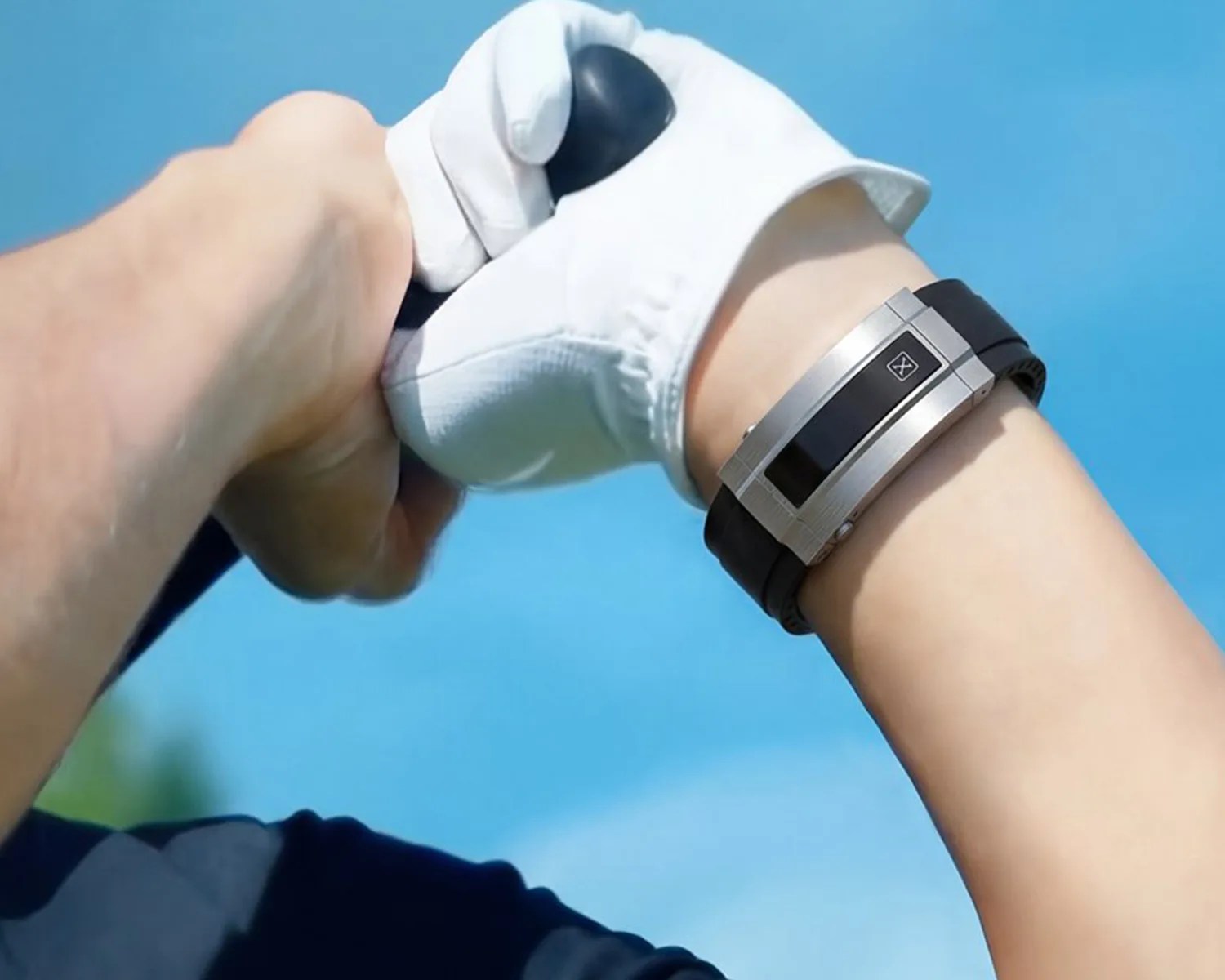 Black and silver digital wristwatch worn on a wrist holding a golf club with a white glove.