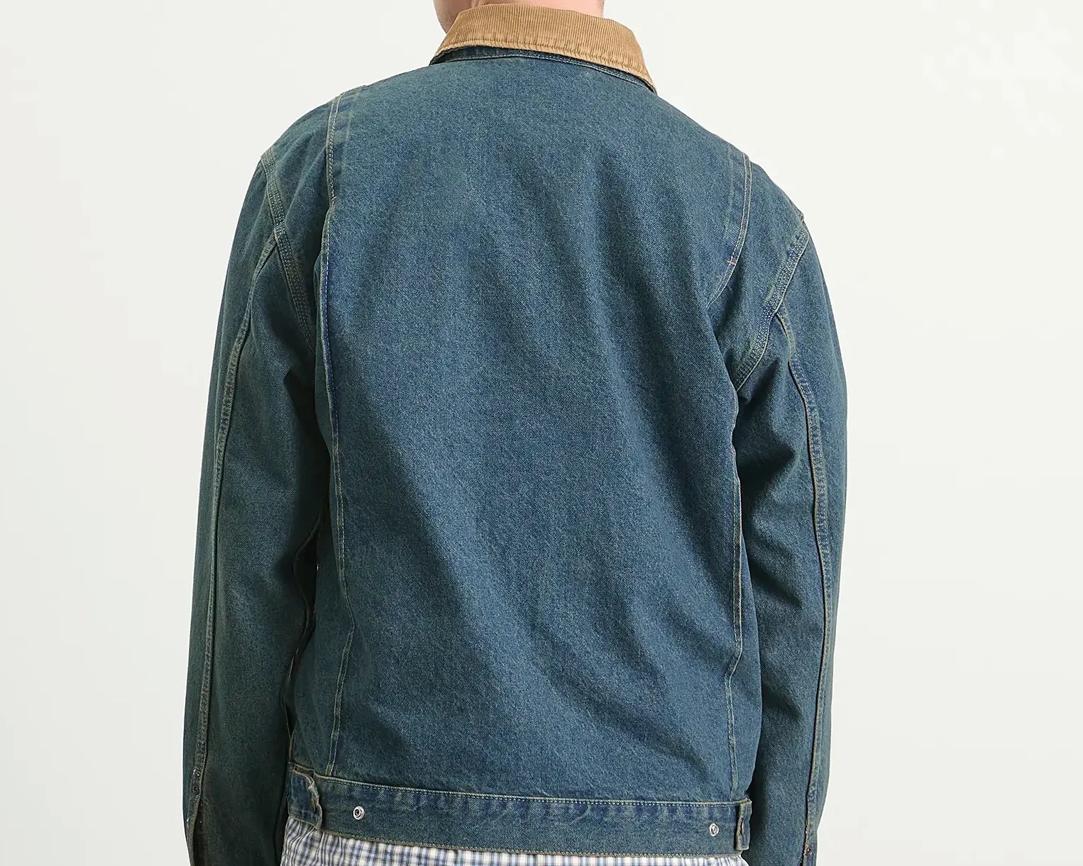 Back view of a blue denim jacket with a tan corduroy collar worn over a checkered shirt.