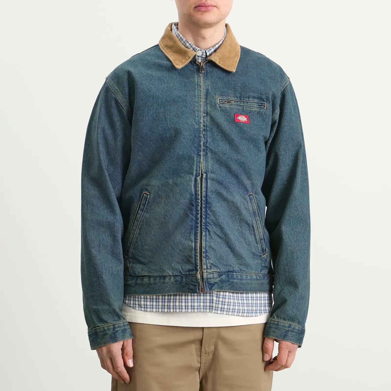 Blue denim jacket with tan corduroy collar and front zipper worn over a checkered shirt.