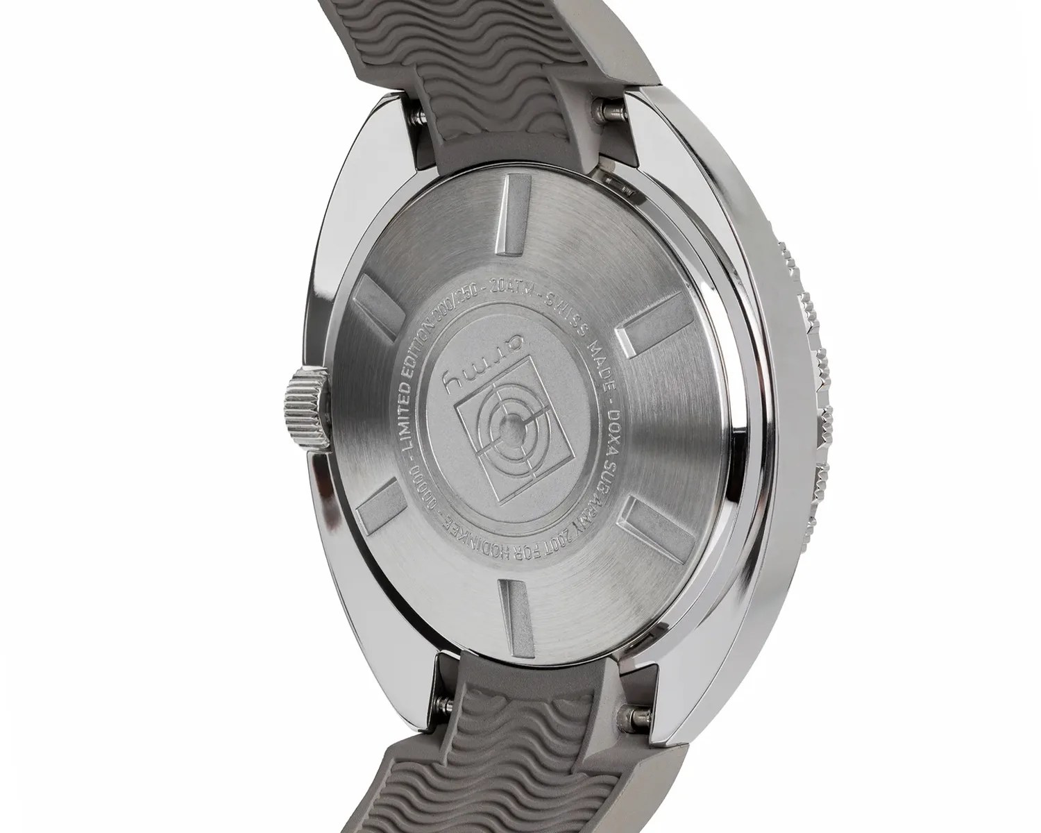 Back of a stainless steel wristwatch case with engraved text and a gray textured rubber strap.