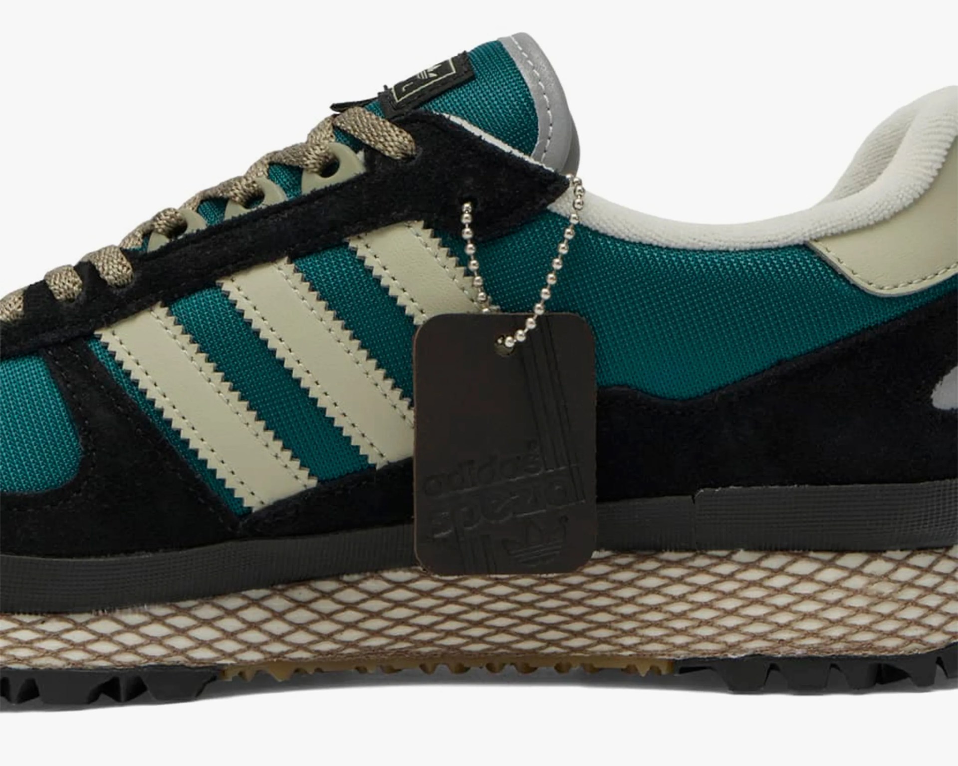 Teal and black Adidas sneaker with beige stripes and textured midsole on a white background.
