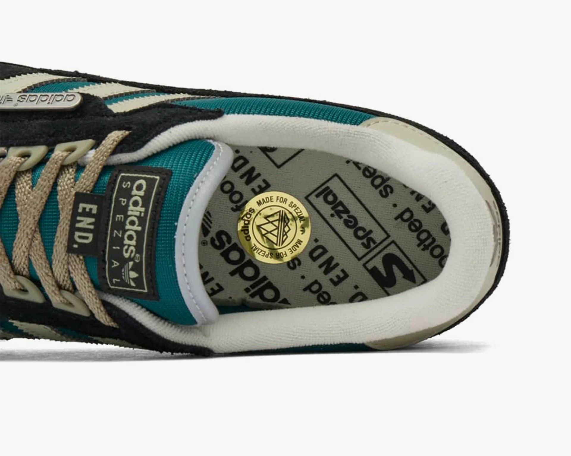 Close-up of teal and black Adidas Spezial sneaker with beige laces and branded insole.