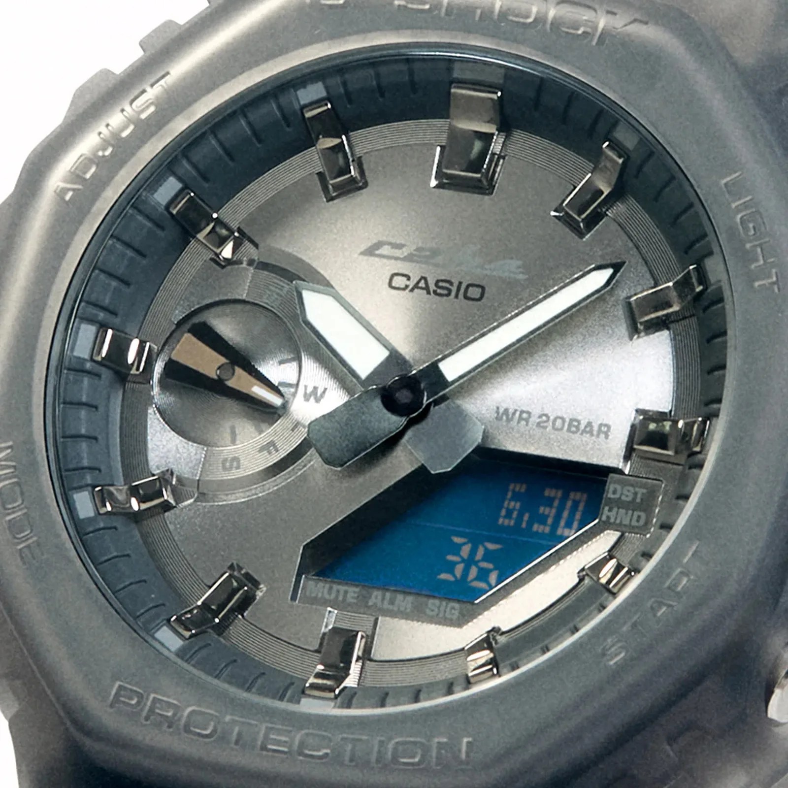 Close-up of a Casio G-Shock watch face with analog hands, digital display, and black protective bezel.