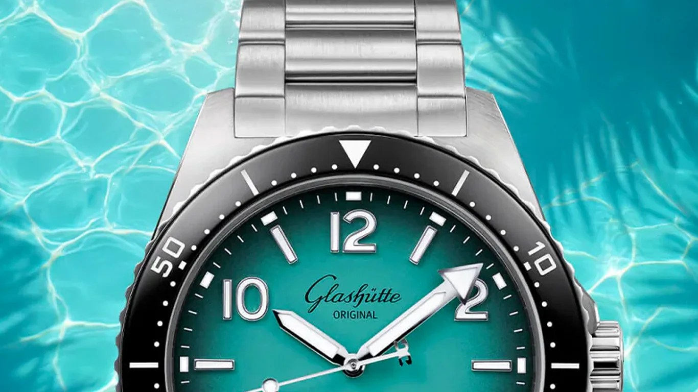 Silver metal wristwatch with a black bezel and teal dial showing the time 10:10:40.