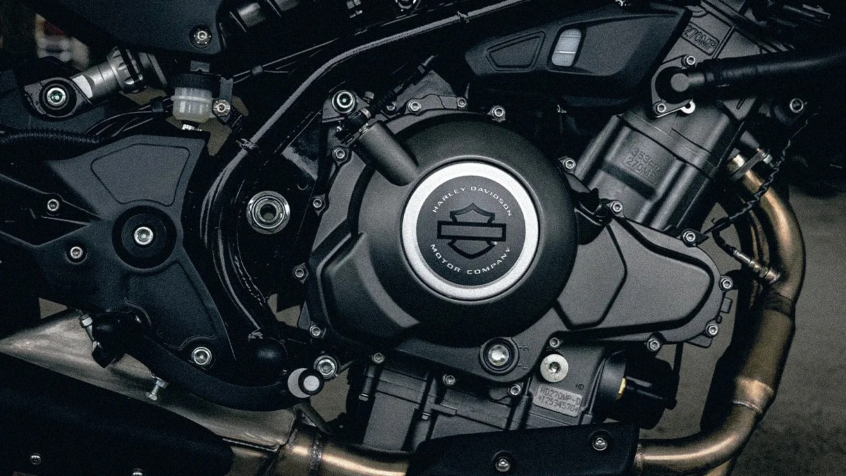 Close-up of a black Harley-Davidson motorcycle engine with visible bolts and exhaust pipes.