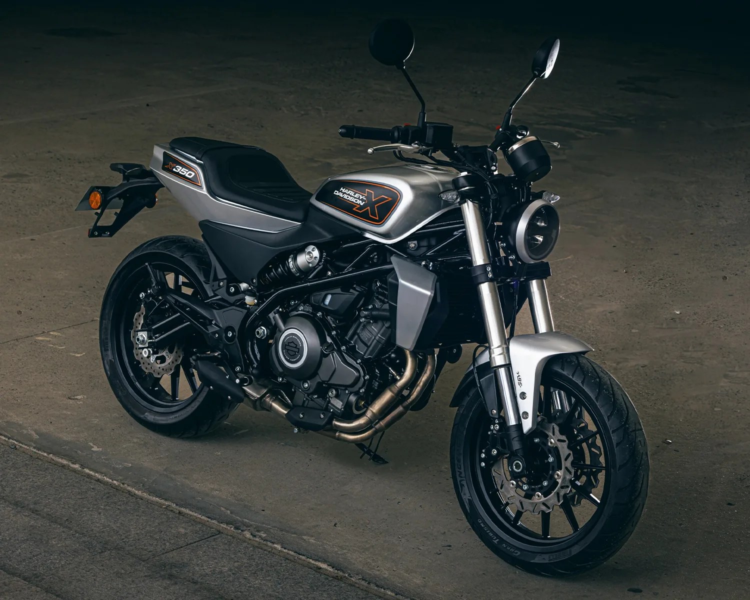 Silver and black Harley-Davidson X350 motorcycle parked on a concrete surface.