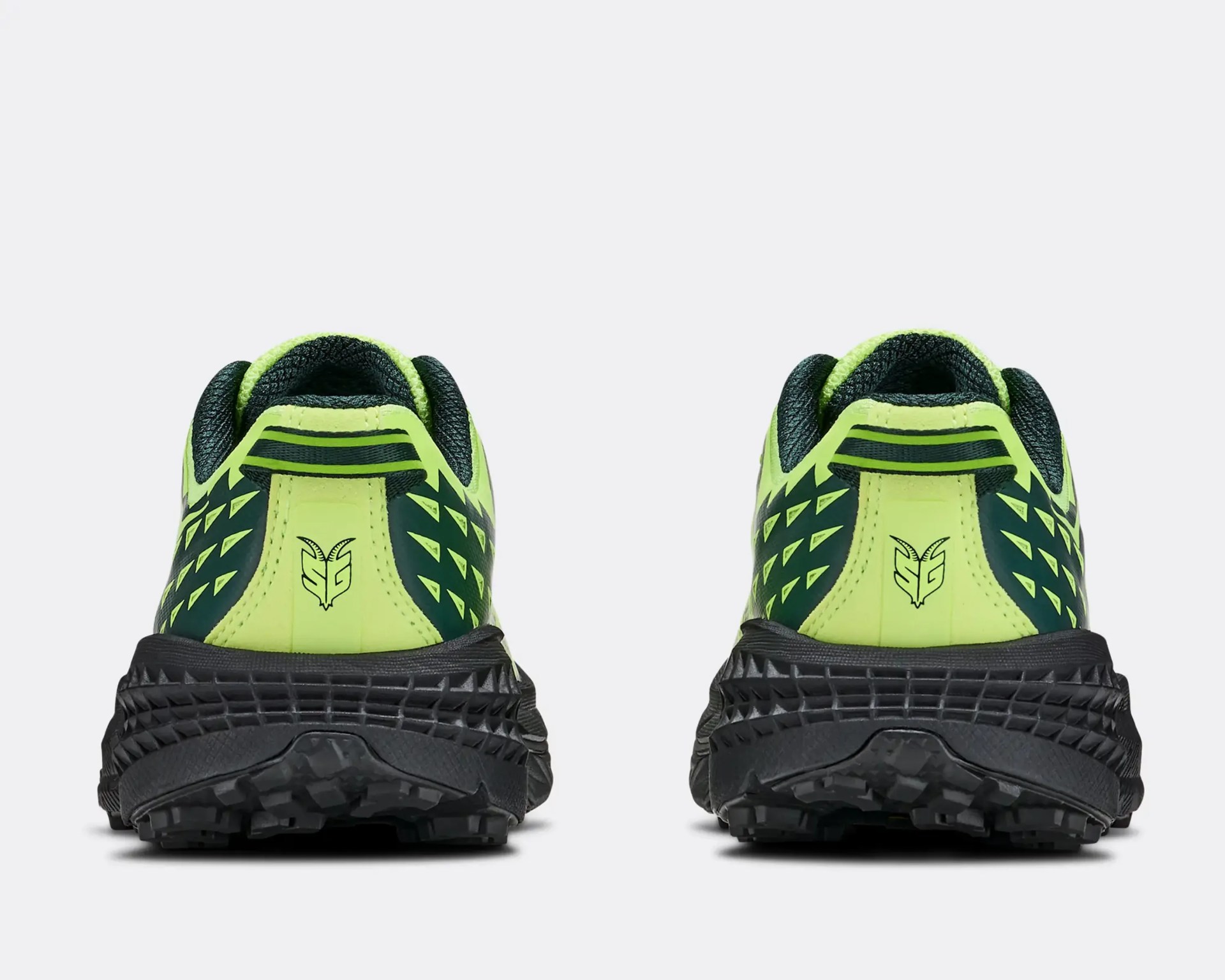 Pair of neon yellow and black trail running shoes viewed from the back showing textured black soles and logo on heel.