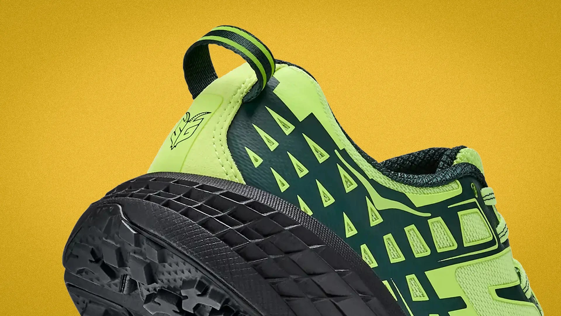 Close-up of a neon green and black athletic shoe heel with textured black sole and pull tab.